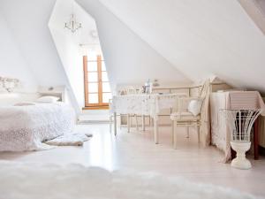 a white bedroom with a white table and chairs at Mooslechners Rusterhof in Rust