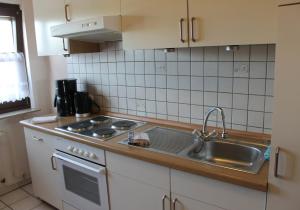 uma cozinha com um lavatório e um fogão forno superior em Ferienwohnung bei Inge und Heinz em Konz