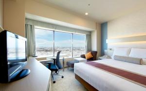 a hotel room with a bed and a large window at Shin Yokohama Prince Hotel in Yokohama