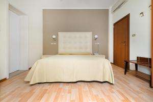 a bedroom with a bed with a yellow blanket on it at Hotel Belsoggiorno in Cattolica