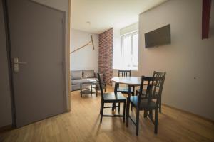 - une chambre avec une table, des chaises et un canapé dans l'établissement Appart Hotel de la Souleuvre, à Le Bény-Bocage