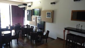 a dining room with tables and chairs and a television at Hotel Leder in Kočani