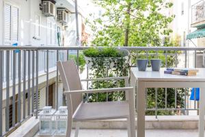 アテネにあるLikavittos Apartmentsの白いテーブルと椅子付きのバルコニー