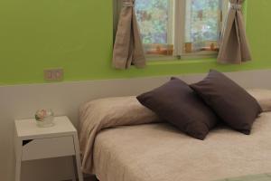 a bedroom with green walls and a bed with two pillows at Camping Aquileia in Aquiléia