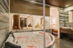 Elixir Hills Suites Resort and Spa في مونار: حمام مع حوض عليه دم
