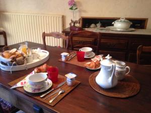 a table with a breakfast of tea and croissants at Les Fleurs in Monpazier