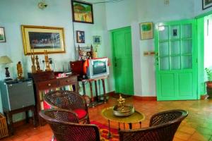 a living room with green doors and a tv at Green Woods Bethlehem in Cochin