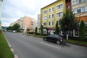 a black car parked on the side of a city street at Apartament TRIDENT 2 in Haţeg