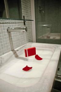 un lavandino in bagno con pedali di fiori rossi di Barceloneta Suites Apartments Beach a Barcellona Altre 7 foto