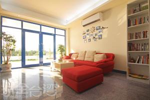 a living room with a red couch and a book shelf at Bay Villa Hall in Jinsha