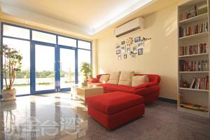 金沙鎮的住宿－金門海灣Villa會館 ，客厅配有红色沙发和书架