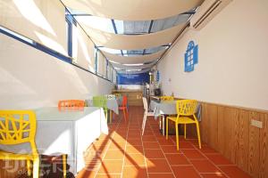 金沙鎮的住宿－金門海灣Villa會館 ，用餐室配有桌子和黄色椅子