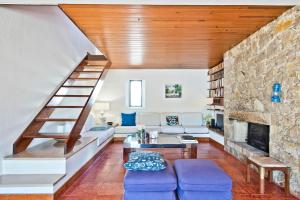 a living room with a staircase and a stone wall at BmyGuest - Sesimbra Country Villa in Sesimbra