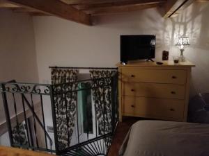 a bedroom with a bed and a dresser with a television at Cà Ro - Casa Rosetta in Tivoli