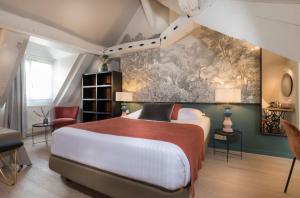um quarto com uma cama e um quadro na parede em Hôtel Jeanne d'Arc Le Marais em Paris