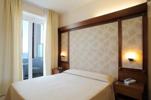 Un dormitorio con una cama grande y una ventana en Grand Hotel Mediterranee, en Alassio