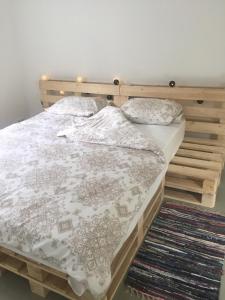 a bed with a wooden frame and pillows on it at Piebalgas street apartment in Cesis in Cēsis