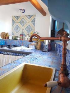a sink in a kitchen with blue and white tiles at Casa Elisa Lipari in Lipari