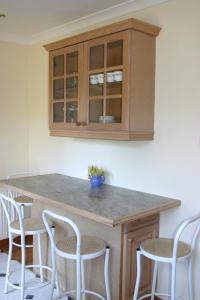 une cuisine avec un comptoir et des chaises autour de la cuisine dans l'établissement Garden Cottage, à Prestwick 15 autres photos