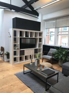 a living room with a large entertainment center with a television at Loft Conversion in Northern Quarter in Manchester