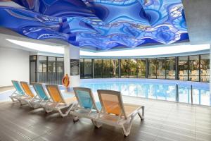 a row of chairs in a pool with a painted ceiling at The Raga Side Ultra All Inclusive in Side