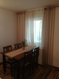 uma mesa de jantar com cadeiras e uma janela em Apartment Brne em Postojna