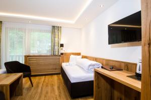 a hotel room with a bed and a desk at Hotel Garni Siegele - Silvretta Card Premium Betrieb in Ischgl