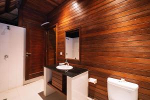 a bathroom with wooden walls and a sink and a toilet at Dodol Lembongan Cliff Sunset in Nusa Lembongan +51 photos