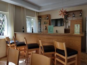 un restaurant avec un bar doté de tables et de chaises en bois dans l'établissement Talitha Kumi Guest House, à Bethléem