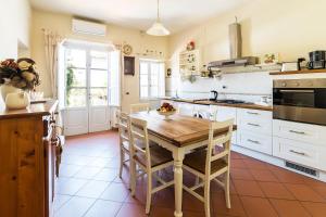 a kitchen with a wooden table and a kitchen with white cabinets at Appartamento La Terrazza in Lucca