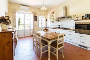 een keuken met een houten tafel en een keuken met witte kasten bij Appartamento La Terrazza in Lucca