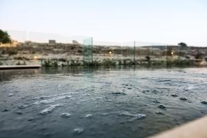 a view of a body of water with a fence at Cesca's Boutique Hotel in Xlendi