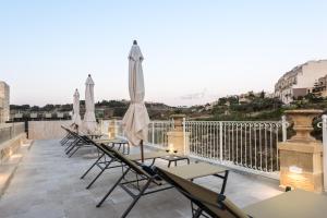 a row of chairs and umbrellas on a roof at Cesca's Boutique Hotel in Xlendi
