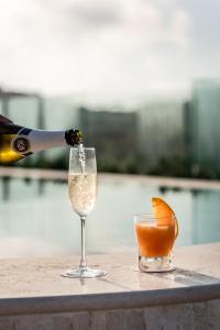a bottle of champagne being poured into a wine glass at Cesca's Boutique Hotel in Xlendi