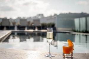 a glass of wine and an orange slice on a table at Cesca's Boutique Hotel in Xlendi