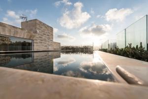 a swimming pool with the sky in the water at Cesca's Boutique Hotel in Xlendi