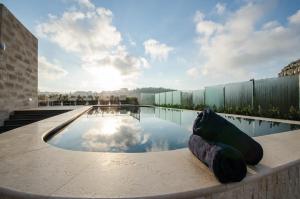 a swimming pool on top of a building at Cesca's Boutique Hotel in Xlendi