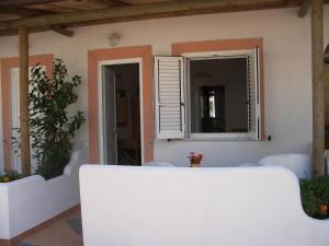 Habitación blanca con ventana y espejo. en Hotel Terme Fiola, en Isquia