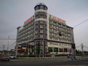 een groot gebouw aan een stadsstraat met een verkeerslicht bij Grand Court Hotel in Teluk Intan