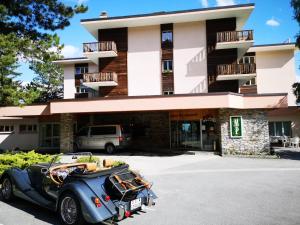 um carro antigo estacionado em frente a um edifício em Hotel-Restaurant Le Mont Paisible, Crans-Montana em Crans-Montana