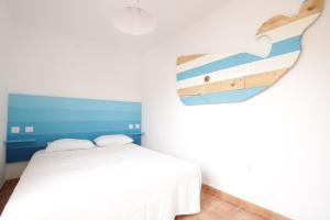 Schlafzimmer mit einem Bett und einem Surfbrett an der Wand in der Unterkunft Casa Silencio in Corralejo