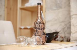 a bottle sitting on top of a table next to glasses at Mendy's Accommodation in Safed