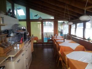 un restaurante con varias mesas en una habitación con ventanas en Pension Pritzl, en Salzweg