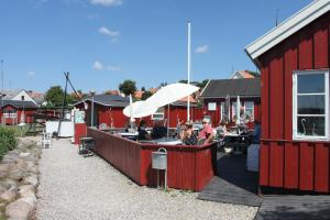 a red building with a bar with people sitting at tables at Hotel Nysted Havn in Nysted