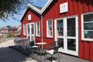a red building with a table and chairs on a deck at Hotel Nysted Havn in Nysted