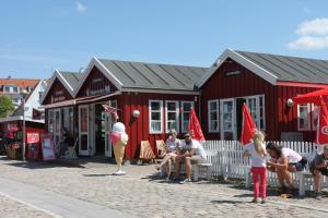 a group of children playing a game in front of a red building at Hotel Nysted Havn in Nysted