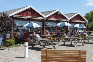 a group of people sitting at tables in front of a building at Hotel Nysted Havn in Nysted