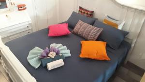 a bed with different colored pillows on it at La piccola casa di Tania in Terlizzi