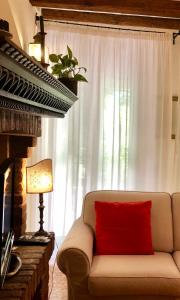 ein Sofa mit einem roten Kissen vor dem Fenster in der Unterkunft Peggy Suite in Venedig