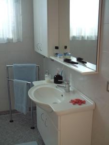 a white bathroom with a sink and a mirror at Residence Hofer in Valdaora